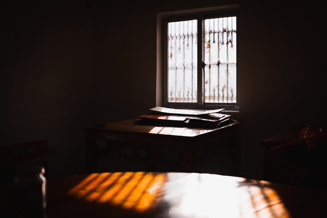 Woman writing in a journal at a sunlit desk