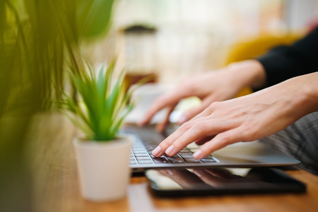 Person writing an email on a laptop at home